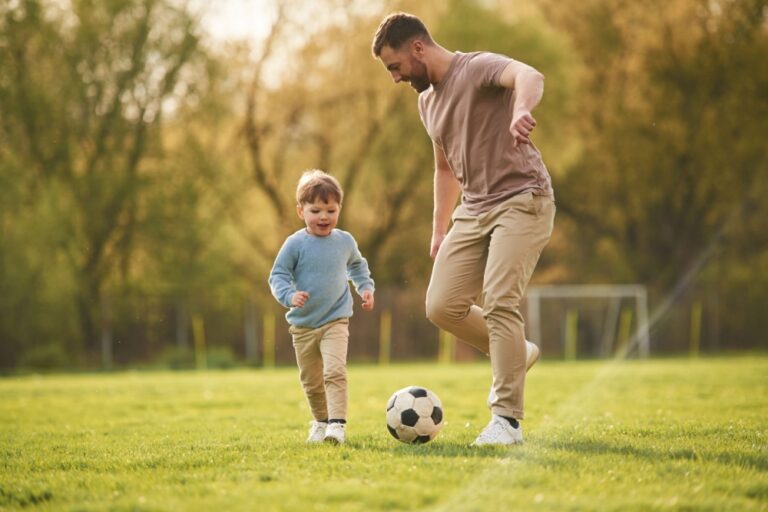 A father playing football with his young son.