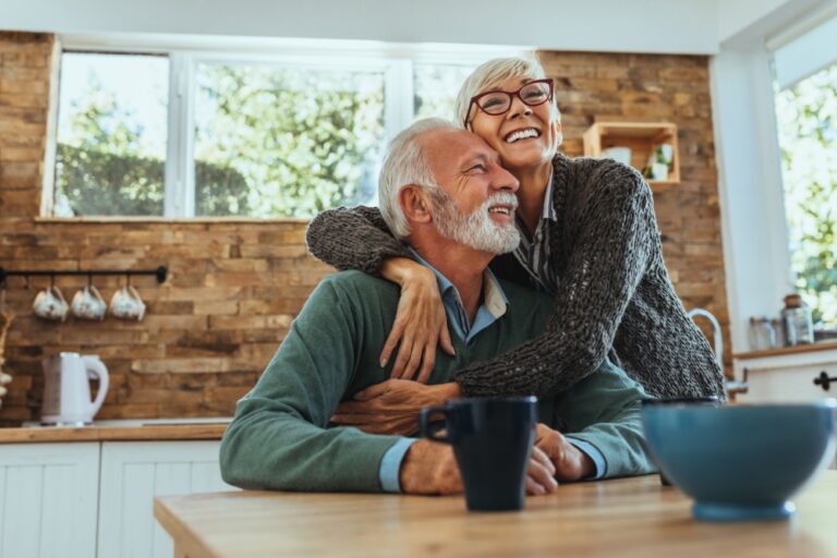 A couple hugging in their home.