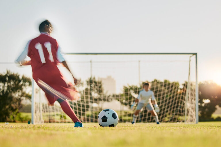 A footballer taking a shot at a goal.