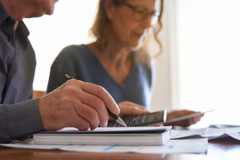 Couple looking at paperwork and using a calculator