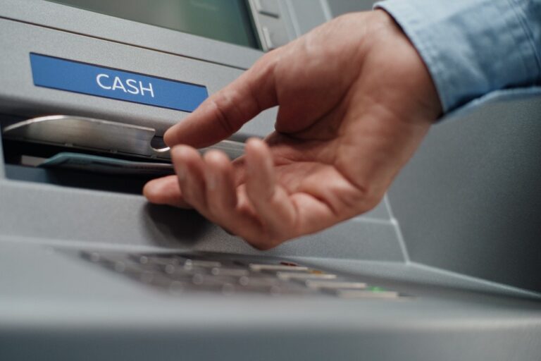 A person using an ATM to withdraw cash.