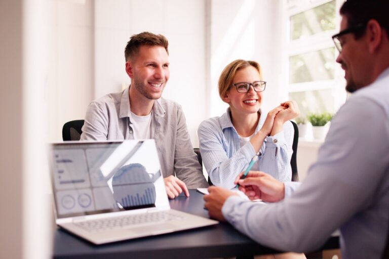 A couple happily talking with their financial planner.