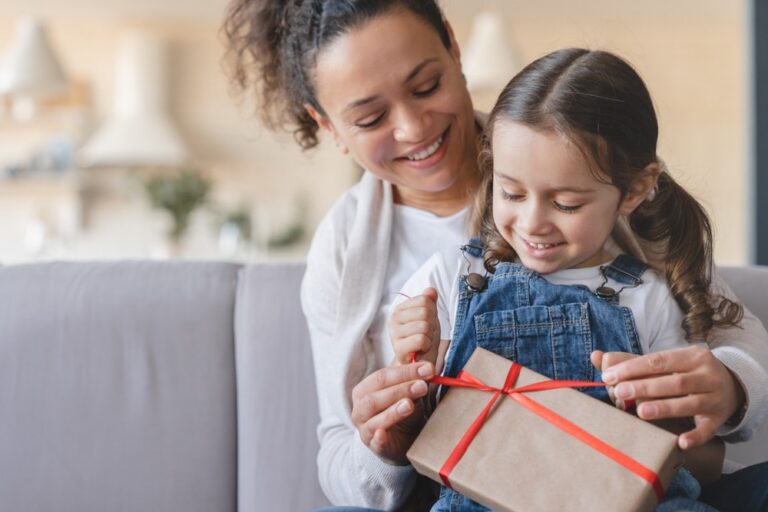 A mother and daughter unwrapping a gift.
