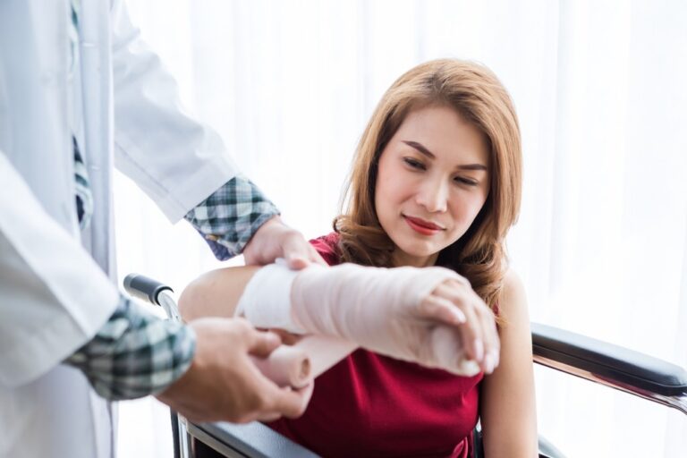 A woman having her arm placed in a cast.